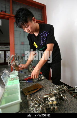 Chi Xiaolong utilise des bidons et des vis pour faire un modèle de transformateurs à Shijiazhuang, province de Hebei, Chine centrale 29 août 2011. 20 ans chinois-ol Banque D'Images
