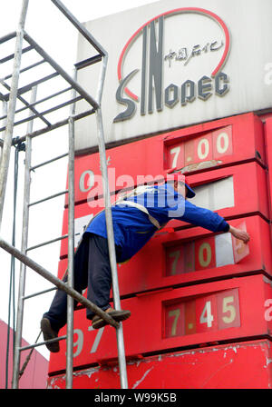 Un travailleur chinois met à jour des prix de l'essence à une station-service de Sinopec à Yichang city, province de Hubei, Chine centrale 20 février 2011. La Chine, bigg Asias Banque D'Images