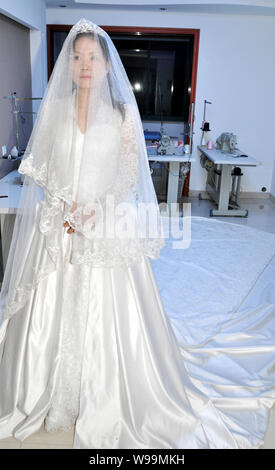 Un mannequin portant une réplique de la robe de la princesse Kate Middleton pose pour des photos dans une robe de mariage studio à Suzhou City, est de la Chine Banque D'Images