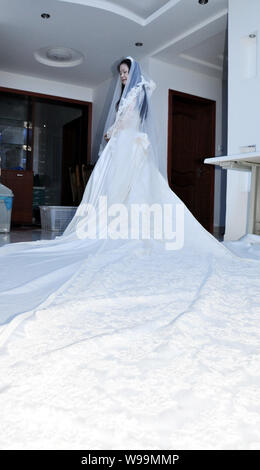 Un mannequin portant une réplique de la robe de la princesse Kate Middleton pose pour des photos dans une robe de mariage studio à Suzhou City, est de la Chine Banque D'Images