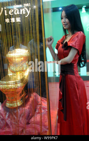 Un modèle pose par l'or toilettes durant le 11e Sommet mondiale des toilettes et Expo à Haikou, province de Hainan, Chine du Sud, du 22 novembre 2011. Le brillant s Banque D'Images