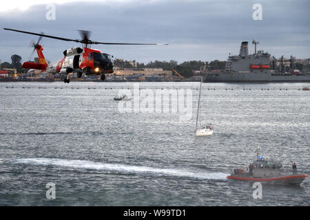 Une Garde côtière canadienne Le Secteur de San Diego MH-60T et un équipage d'hélicoptère Jayhawk Station San Diego Réponse Boat-Medium de 45 pieds conduite de l'équipage une démonstration de recherche et de sauvetage dans la région de San Diego le 10 août 2019. La démonstration faisait partie de film nuit à bord de l'allée centrale, qui comprenait un examen préalable du tuteur. (U.S. Vidéo de la Garde côtière par Maître de 1ère classe Patrick Kelley) Banque D'Images