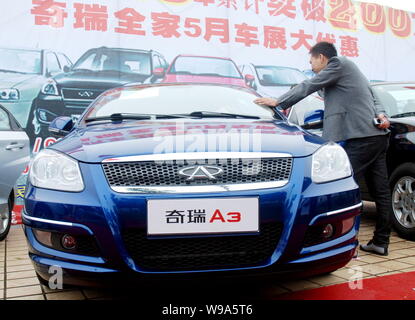 --FILE--une voiture acheteur chinois regarde une Chery A3 lors d'une auto show de Shaoyang, dans la province de Hunan, Chine centrale, 16 mai 2010. Le plus grand Banque D'Images