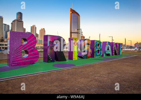 Les lettres colorées de l'orthographe du nom de la ville de Brisbane, s'asseoir sur Southbank Parklands avec les bâtiments de la ville comme toile de fond. Banque D'Images