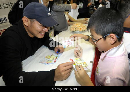 Acteur kungfu chinois Jet Li présente une carte avec sa signature à un enfant au cours d'une activité de bienfaisance afin de sensibiliser spéciale pour le séisme de Yushu touchés dans northwe Comté Banque D'Images