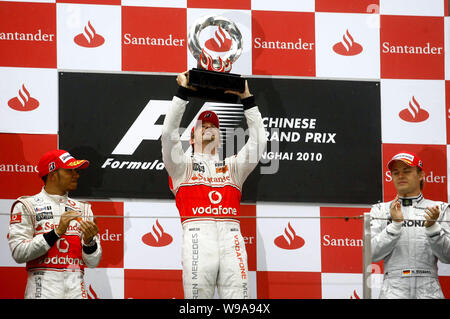 La F1 Jenson Button de McLaren Mercedes, centre, soutient le trophée de champion à côté de son coéquipier Britannique Lewis Hamilton, à gauche, et l'unité allemande Banque D'Images