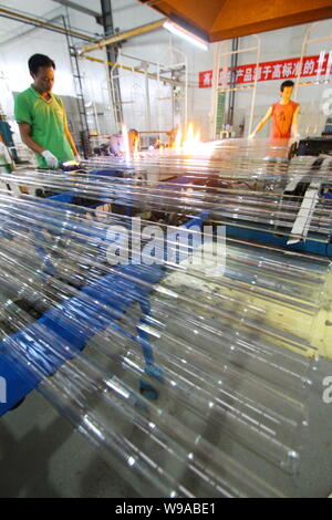 Les travailleurs chinois de la fabrication de tubes à vide solaires dans une usine de la société solaire Himin pour Qingdao city, dans la province de Shandong, Chine de l'Est, 17 juillet 2010. Banque D'Images