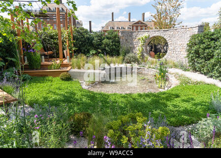 Jardin avec stone 'Moon fenêtre' wall Banque D'Images