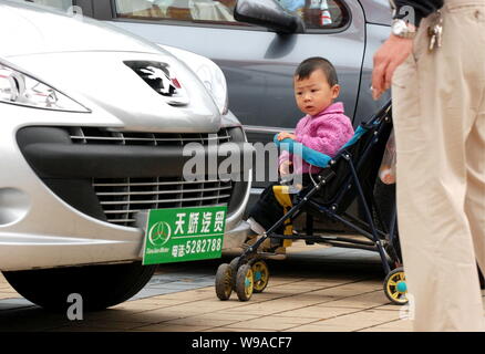 --FILE--un enfant chinois ressemble à une voiture Peugeot lors d'une auto show de Shaoyang, dans la province de Hunan, Chine centrale, 15 mai 2010. Le plus grand au Banque D'Images