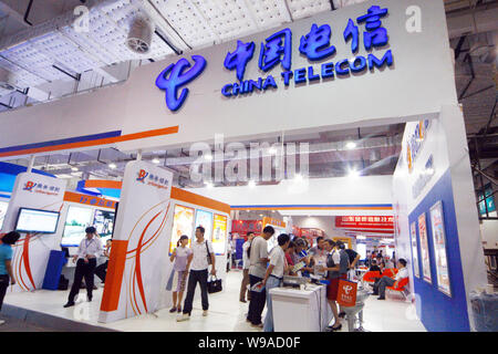 --FILE--Local des résidents chinois devant une personnel branchChinese introduire des produits et services aux visiteurs sur le stand de China Telecom lors d'une ex Banque D'Images