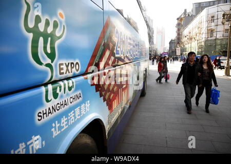 Les résidents locaux chinois passons un bus avec publicité pour l'Exposition universelle Shanghai 2010, à Tianjin, Chine, 1 avril 2010. Avec le approachi rapide Banque D'Images