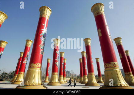 Les résidents chinois passent devant les colonnes de l'unité nationale dans le Parc olympique de Beijing, Chine, 2 février 2010. Les colonnes de l'unité nationale 56 Banque D'Images