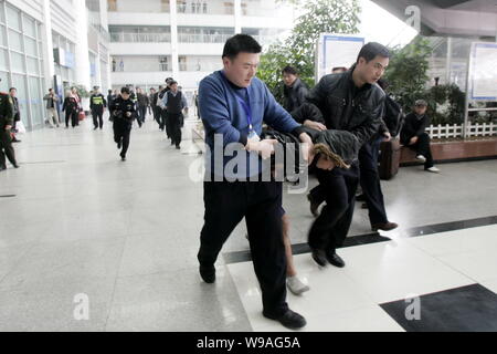 Les agents de police chinois arrêter un homme qui a tenté de se suicider après qu'il a été ramené d'une traverse à l'Fuzhou Railway Station in Fuzho Banque D'Images