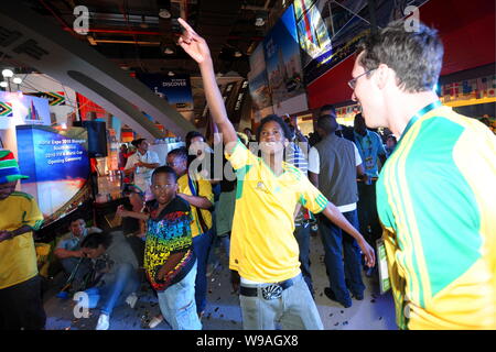 Soccer fans et visiteurs de l'expo cheer tout en regardant le match d'ouverture de la Coupe du Monde 2010 entre l'Afrique du Sud, Mexique et d'Afrique du Sud pied national Banque D'Images