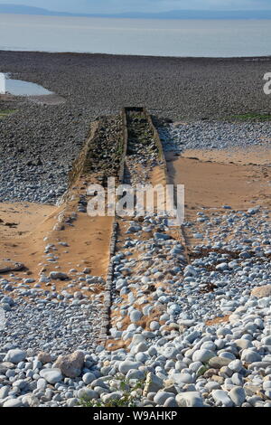 Un homme fait beach épi conçu pour empêcher des sables mouvants de quitter une zone de plage et les rochers et sables tenant en échec le ralentissement de l'érosion. Banque D'Images