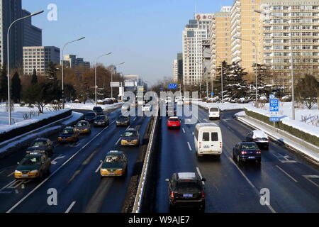 Les voitures roulent sur une rue après de fortes chutes de neige ont été déblayés à Beijing, Chine, le lundi 4 janvier 2010. Beijing a vu circulation lundi Banque D'Images