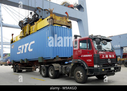 --FILE--une grue charge un camion avec un récipient dans un terminal de conteneurs dans la zone sous douane Waigaoqiao de Shanghai, Chine, le 14 juillet 2010. Les ports de Shan Banque D'Images