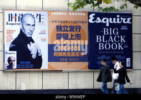 Les résidents locaux chinois passent devant une affiche publicitaire pour la version chinoise de Esquire 2010 numéro de novembre avec l'image de l'ancien football français Banque D'Images