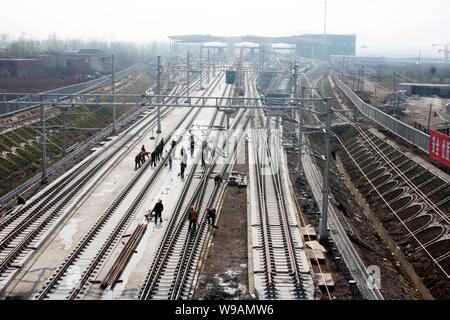 Les travailleurs chinois jeter voies des chemins de fer à grande vitesse Beijing-Shanghai à la gare sud de Bengbu dans ville de Bengbu east, la province de l'Anhui, Chine Banque D'Images