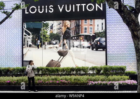 --FILE--Une femme chinoise marche dernières la Louis Vuitton (LV) flagship store à l'Lippo Plaza à Shanghai, Chine, le 5 mai 2010. Les produits de luxe français beh Banque D'Images