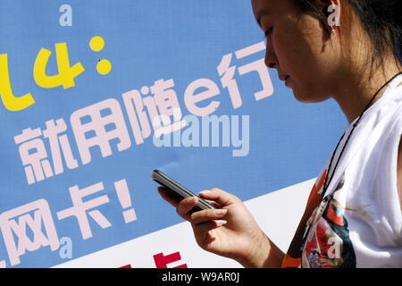 --FILE--une jeune femme chinoise utilise son téléphone mobile à Haikou City, province de Hainan, Chine du Sud 13 septembre 2009. La Chine a commencé le mercredi (1 S Banque D'Images