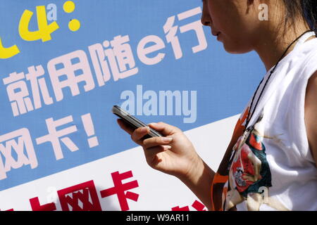 --FILE--une jeune femme chinoise utilise son téléphone mobile à Haikou City, province de Hainan, Chine du Sud 13 septembre 2009. La Chine a commencé le mercredi (1 S Banque D'Images