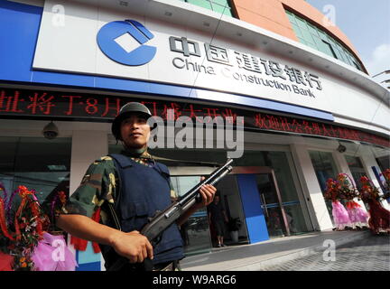 --FILE, un personnel de sécurité chinois armés montent la garde devant une succursale de la Banque de Construction de Chine (BCC), dans la ville de Nantong, Chine de l'Est Banque D'Images