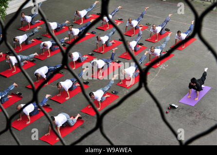 27 Les détenus chinois et un professeur de yoga Yoga effectuer dans une prison de la ville de Chengdu, province du Sichuan, Chine du sud-ouest 18 juin 2010. Les prisonniers 27 wi Banque D'Images