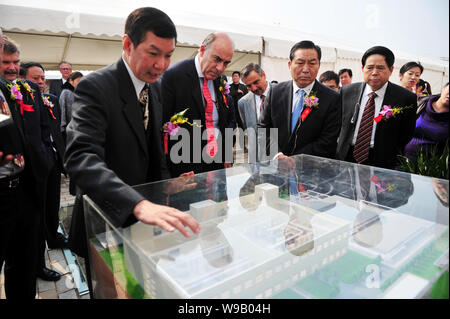 Centre, Muhtar Kent, président et directeur général de The Coca-Cola Company, et d'autres cadres et fonctionnaires s'inspirer d'un modèle de l'usine d'embouteillage de Swire Co Banque D'Images