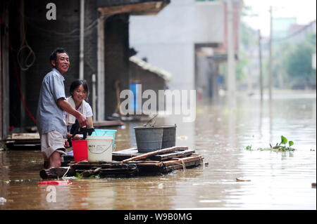 Les résidents locaux chinois lavez les vêtements avec l'eau de l'inondation sur une rue inondée à Fuzhou City, province de Jiangxi, Chine de l'est le 25 juin 2010. Inondations en Chine Banque D'Images