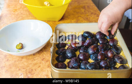 La grand-mère gâteau aux prunes. Des pâtisseries maison. Un gâteau aux fruits. Part d'une femme âgée à travaux cuisine Banque D'Images