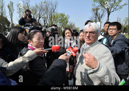 Bernie Ecclestone (C), Commercial Supremo de la Formule 1 (F1), est entouré par des journalistes sur le Circuit International de Shanghai park à Shanghai Banque D'Images