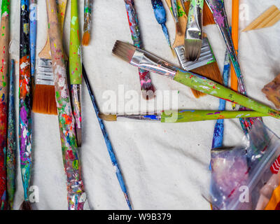 Pinceaux d'artiste. Mise à plat de nombreux outils de l'artiste sur le tissu blanc, équipement technique. Banque D'Images