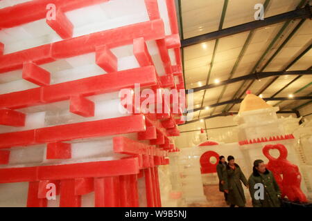 Les travailleurs chinois à pied passé une sculpture de glace du pavillon de la Chine pour l'Exposition universelle Shanghai 2010 dans un monde de glace dans la ville de Nantong Jiangsu, Chine de l'Est Banque D'Images