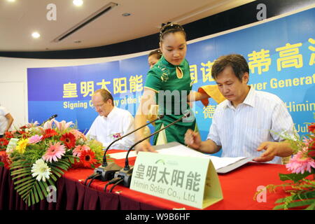 Huang Ming, droite, président et président de la société solaire Himin pour, et un représentant de Novatec BioSol AG signer des ententes au cours d'une signature cerem Banque D'Images