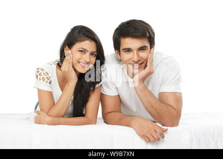 Jeune couple lying on the bed and smiling Banque D'Images