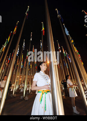 Le personnel de l'Expo rentrer les drapeaux nationaux des pays participant à l'Exposition Universelle de Shanghai après la clôture de l'Exposition Universelle de 2010 dans le parc de l'Expo Banque D'Images