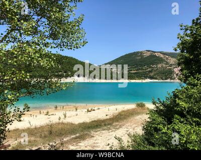 Lac Fiastra, région des Marches, en Italie. Lac Fiastra est un lac artificiel dont le travail a commencé en 1955 avec l'objectif de fournir de l'électricité dans la vallée de Fiastrone et est situé dans la région de Fiastra dans la province de Macerata dans les marches. Sa superficie est de 2 km². Le lac est situé dans le parc national des montagnes de Sibillini et est alimenté par les eaux de la rivière Fiastrone et petits petits affluents qui créent des coins charmants. Le lac est très célèbre pour des événements importants tels que le "Triathlon de la montagnes de Sibillini' ou de nombreux concours de pêche. Banque D'Images