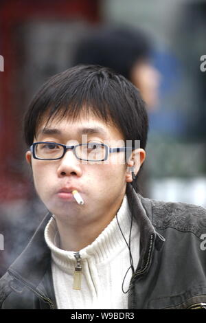 --File-- Un jeune homme chinois fume dans une rue de Shanghai, Chine, le 5 mars 2009. Selon un rapport de Reuters, une récente étude menée sur le tabac b Banque D'Images