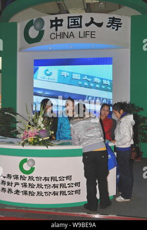 --File-- employés chinois et les visiteurs sont accueillis à un stand de China Life lors d'une exposition à Changsha, Province du Hunan, Chine centrale, 26 Décembre 20 Banque D'Images