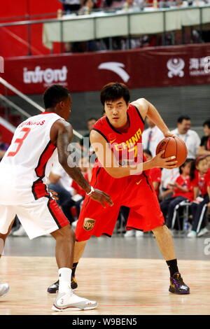 Chines Wang Shipeng, droite, tente de briser NBA basketball player Brandon Jennings du Milwaukee Bucks dans un match de basket-ball entre le Chi Banque D'Images