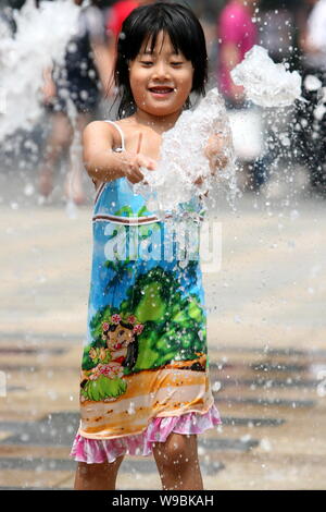 Une jeune Chinoise cools off dans une fontaine à un centre commercial dans la chaleur écrasante météo à Pékin, Chine, 24 juillet 2010. Pékin connaît ses lon Banque D'Images