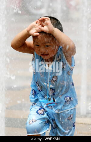 Un garçon chinois refroidi dans une fontaine à un centre commercial dans la chaleur écrasante météo à Pékin, Chine, 24 juillet 2010. Pékin connaît ses longues Banque D'Images