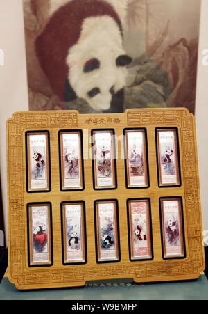 Un ensemble de 10 barres d'argent sur le thème du panda pour l'Exposition Universelle de 2010 sont vus en face de peintures de l'Expo 10 pandas lors d'une cérémonie de lancement à Shanghai Banque D'Images