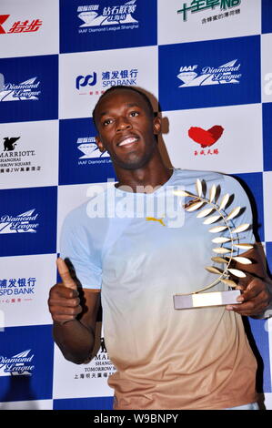 Jamaican mens 100m et 200m record du monde Usain Bolt détient un trophée lors d'une conférence de presse pour l'IAAF Diamond League Shanghai Rencontrez Banque D'Images