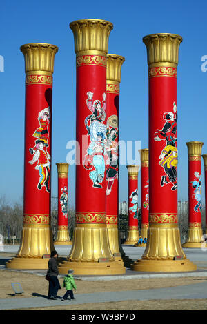 Les résidents chinois passent devant les colonnes de l'unité nationale dans le Parc olympique de Beijing, Chine, 29 janvier 2010. Les colonnes de l'unité nationale 56 Banque D'Images