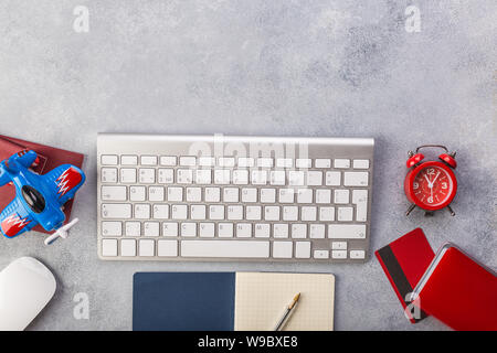 Avion avec près de passeports de payer par carte de crédit et le clavier. Réservation de billets en ligne concept. Un gain de temps. Horloge rouge, fond gris. Banque D'Images