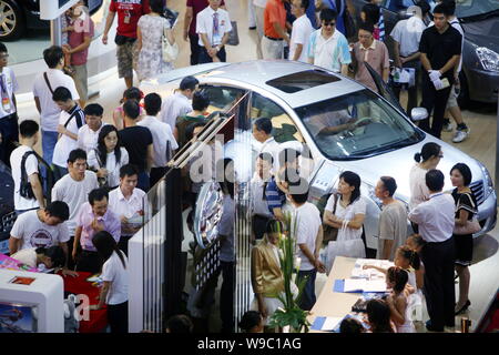 --FILE--Foule de visiteurs regarder les voitures Nissan de l'afficheur pendant un auto show à Foshan, province du Guangdong, Chine du Sud 12 septembre 2009. Le Ni Banque D'Images