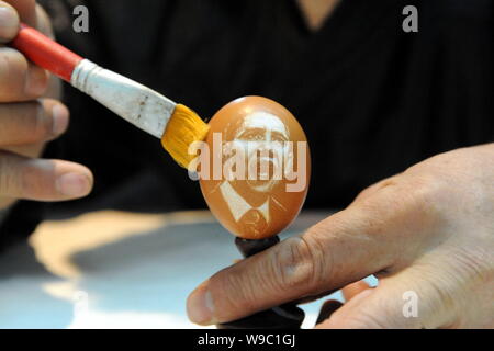 Sculpteur folk chinois Kang brosses Yongguo la coquille d'un oeuf de poule avec le portrait du président américain Barack Obama à son studio à Shenyang city, Banque D'Images