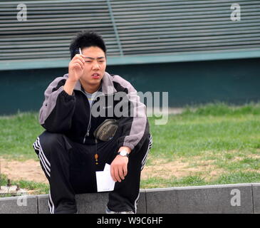 --FILE--un jeune homme chinois fume dans une rue de Beijing, Chine, 15 avril 2008. Liu Zejun, le directeur de l'Aiguo Weisheng Beijing Commission, h Banque D'Images